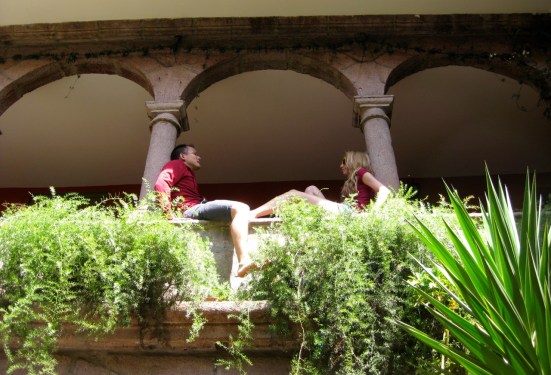 A couple travelers chatting in the archway at Ecopackers. Cusco, Peru.